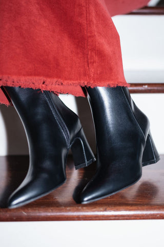 black vegan leather booties with a sleek pointed toe and sturdy block heel