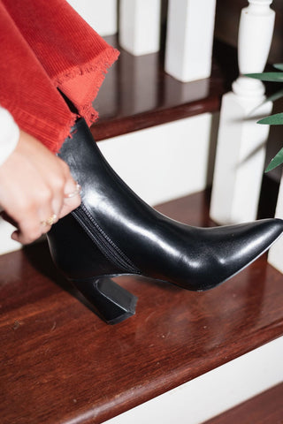 black vegan leather booties with a sleek pointed toe and sturdy block heel, side view