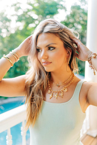 Gold chain link necklace with sea creature charms.