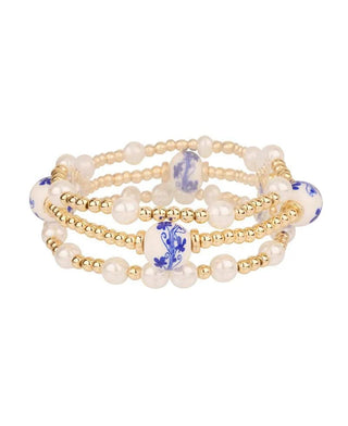 Gold elastic bracelet with pearl and porcelain detailing.