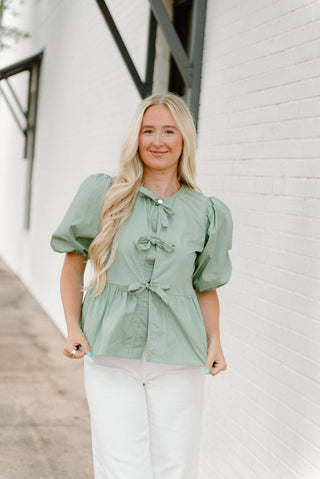 Sage peplum blouse with front bows and puff sleeves