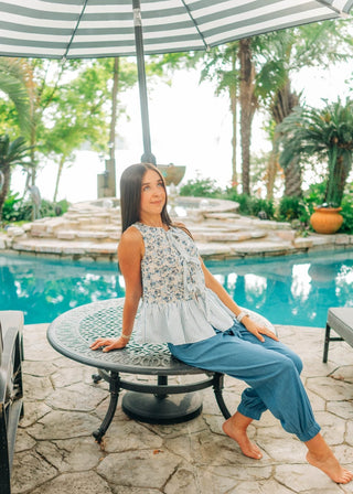 Sleeveless blue and white floral top and stripes. Open front with adjustable ties. Sizes small-large 