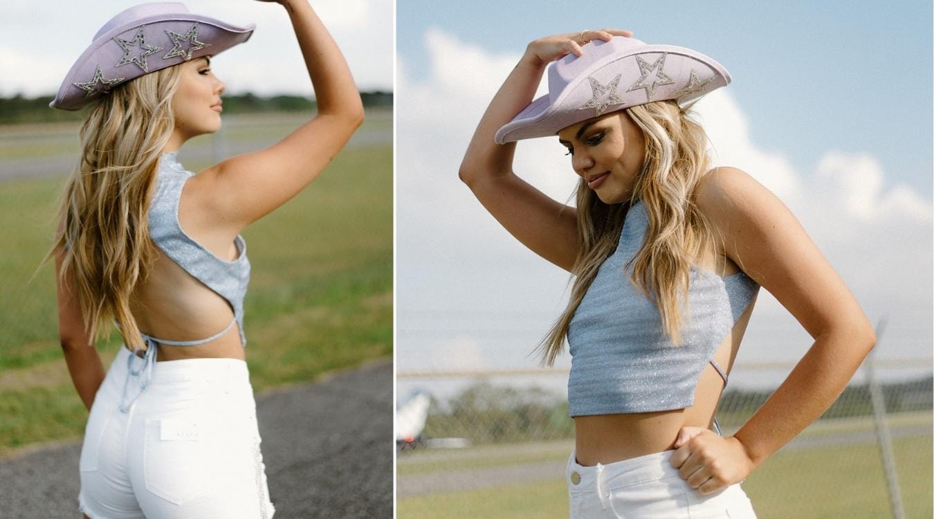 blue metallic mock neck sleeveless open tie back crop top and white rhinestone fringe denim high waisted shorts with lavender purple star glitz cowgirl hat