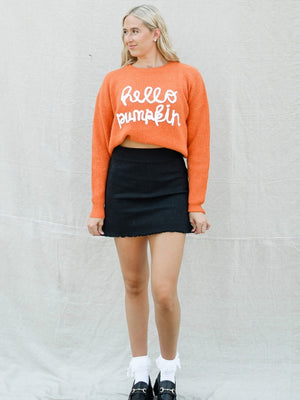 orange hello pumpkin knit long sleeve oversized sweater with black denim mini skirt and black loafers