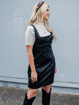 black vegan leather sleeveless square neck mini dress with oatmeal mock neck short sleeve knit top and black knee high cowgirl boots
