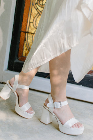 shimmery white finish heel with a square toe, platform, and chunky heel with pearl buckle detail, side view