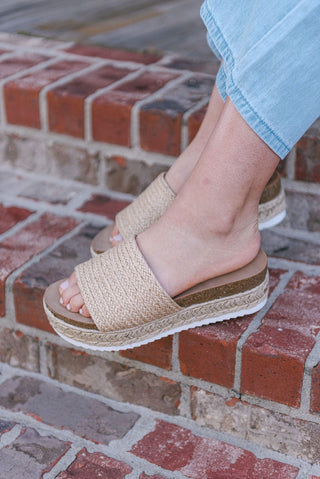 Sandals with a woven design and a rounded toe, slip on style and a platform sole for added height