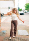 Brown high waisted straight leg jeans with a frayed hem.