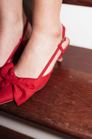 red soft faux suede kitten heel with a pointed toe and delicate bow, adjustable buckle strap, details view