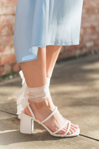 classic white hue and sparkling rhinestone detail heels with a lace up ankle and sturdy block heel, side view